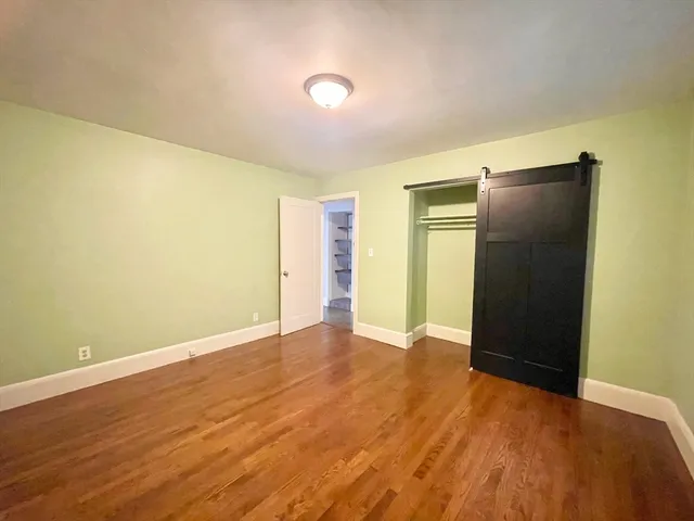 an empty room with wooden floor and closet