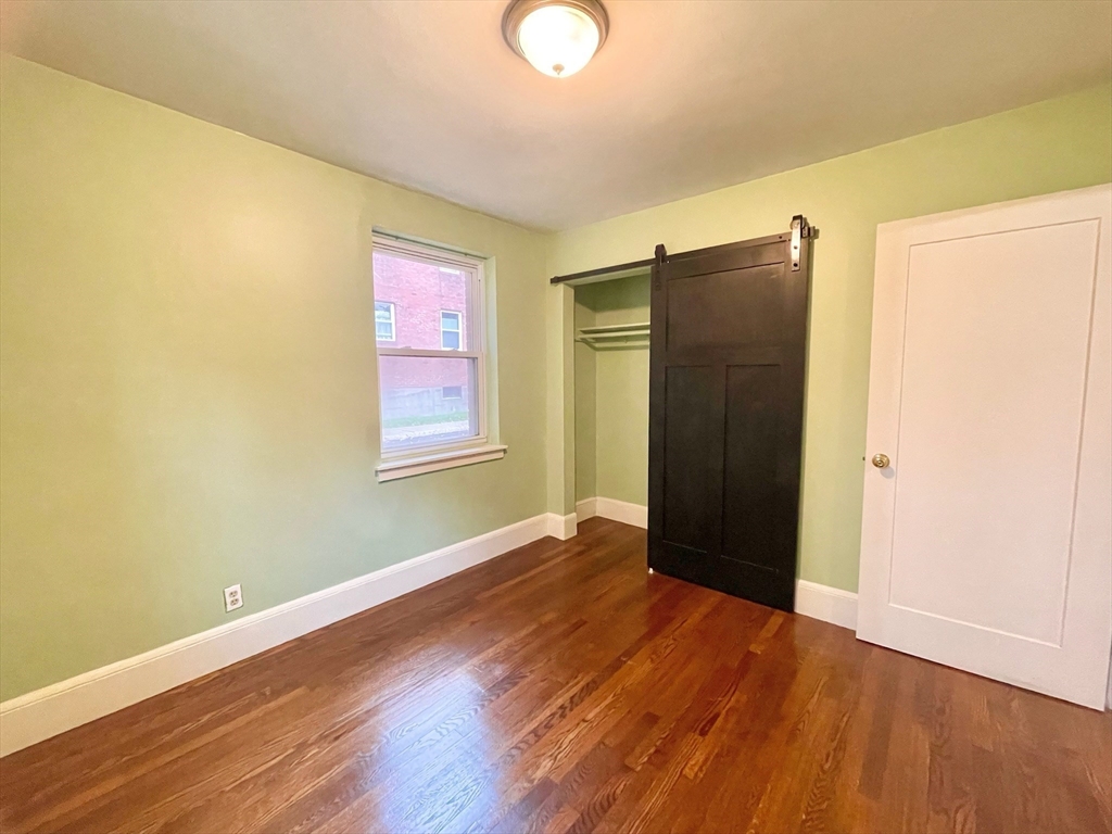 1 O'Leary Way, Unit 91 Boston, MA 02130 - Photo 10 of 12 an empty room with wooden floor and windows