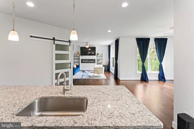 a kitchen with kitchen island granite countertop a sink a counter top space appliances and cabinets