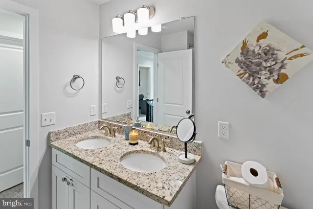 a bathroom with a granite countertop double vanity sinks and a mirror