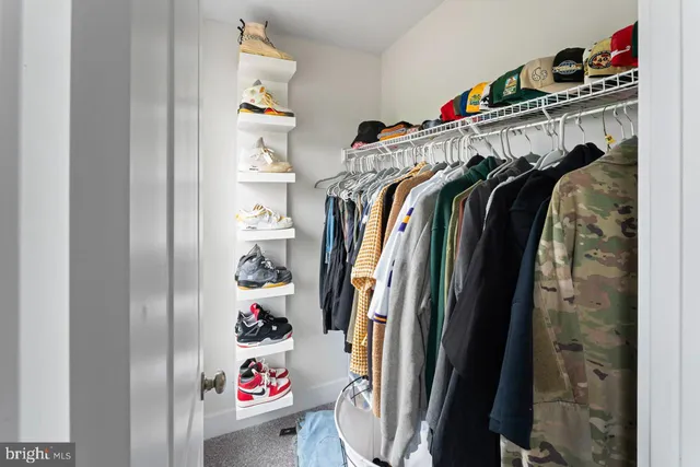 a view of walk in closet with clothes and shoes