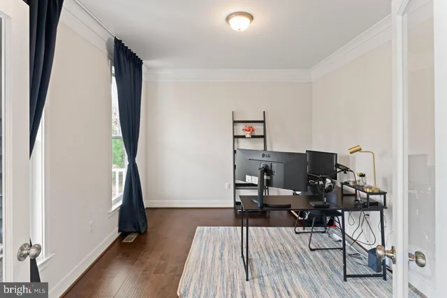 a view of a workspace with furniture and wooden floor