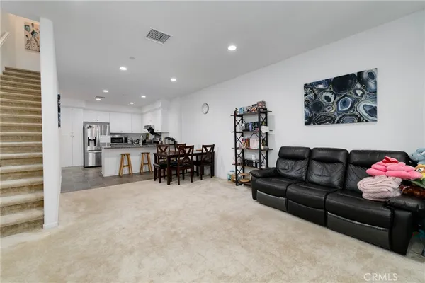 a living room with furniture and kitchen view
