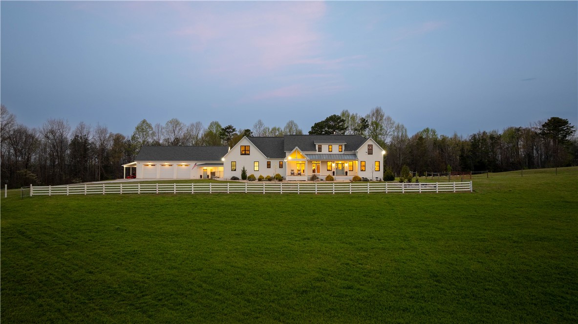 This expansive estate features a classic facade and a vast, verdant lawn, perfect for serene living.