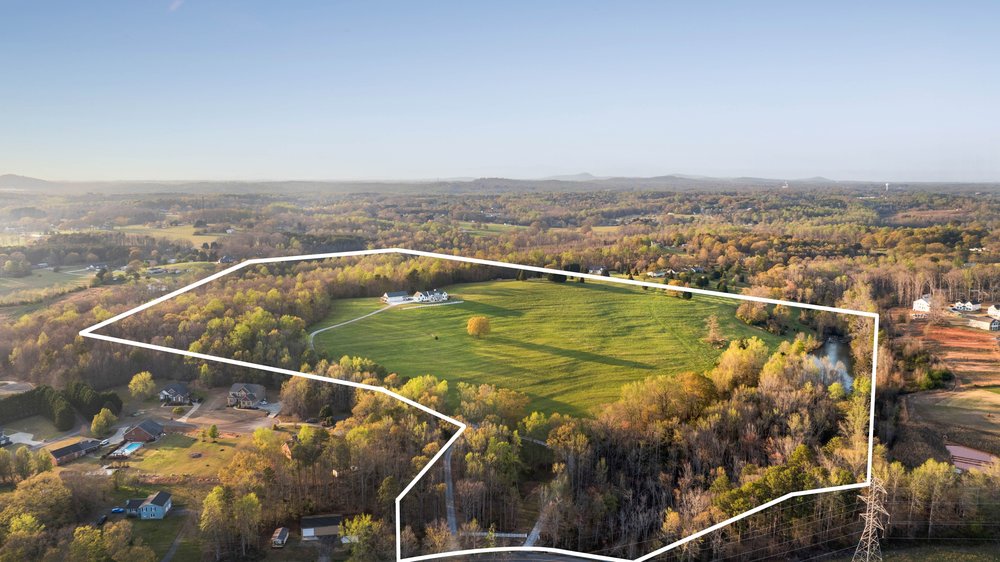 331 Bakerville Road Easley, SC 29642 - Photo 42 of 43 Vast green acreage with a distant residence and abundant trees, perfect for a private estate.