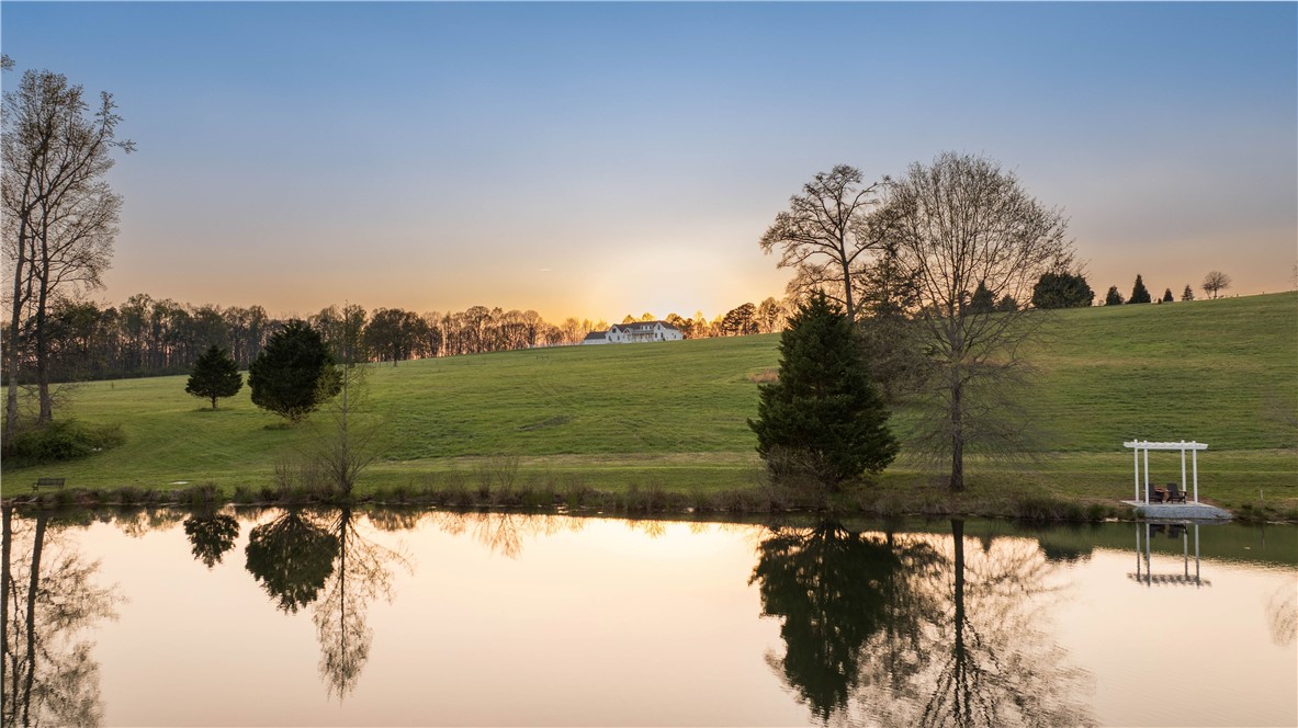 331 Bakerville Road Easley, SC 29642 - Photo 43 of 43 Experience tranquil waterfront living with expansive green pastures and serene pond views.