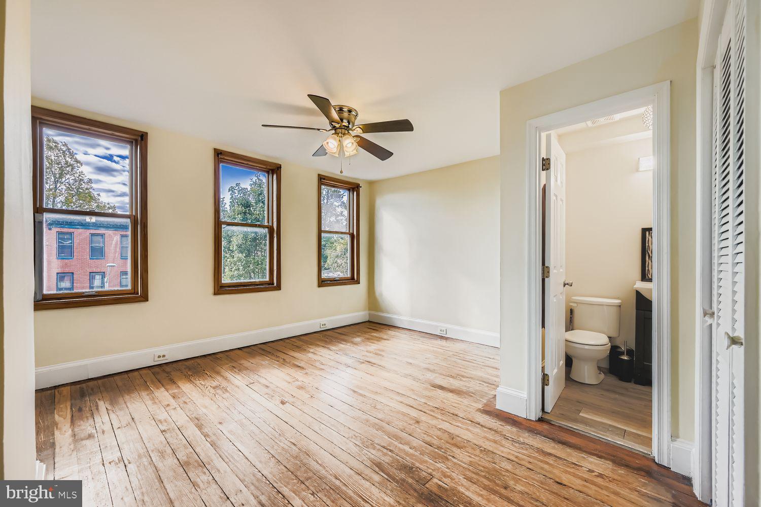 113 South Stricker Street Baltimore, MD 21223 - Photo 22 of 29 a view of a room with wooden floor ceiling fan and windows