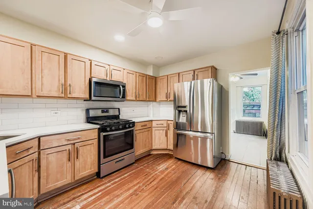 a kitchen with a refrigerator stove and wooden cabinets