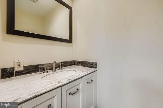 a bathroom with a granite countertop sink and a mirror