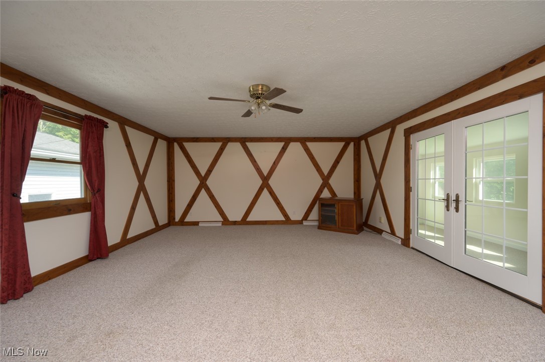 6600 Peck Road Ravenna, OH 44266 - Photo 19 of 50 Unfurnished room with a textured ceiling, light colored carpet, french doors, and ceiling fan