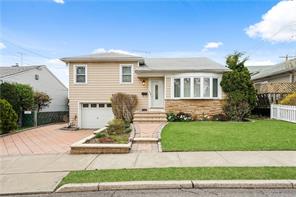 a front view of a house with a yard and potted plants