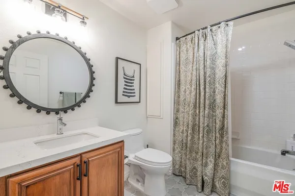 a bathroom with a sink a mirror a toilet and shower