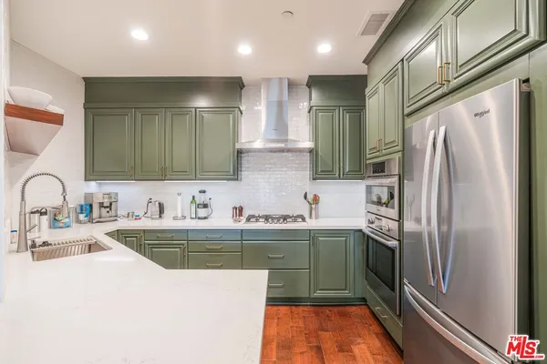 a kitchen with stainless steel appliances granite countertop a sink and a refrigerator