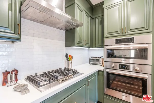 a kitchen with stainless steel appliances granite countertop a stove and a microwave