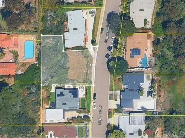 an aerial view of residential houses with outdoor space and parking