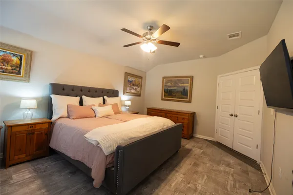 a bedroom with a bed and a flat tv screen on dresser