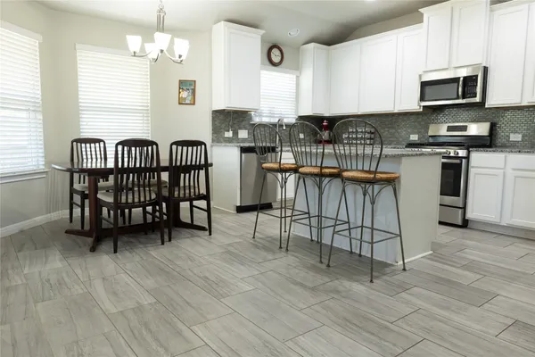 a kitchen with stainless steel appliances granite countertop a stove a sink a microwave and a refrigerator