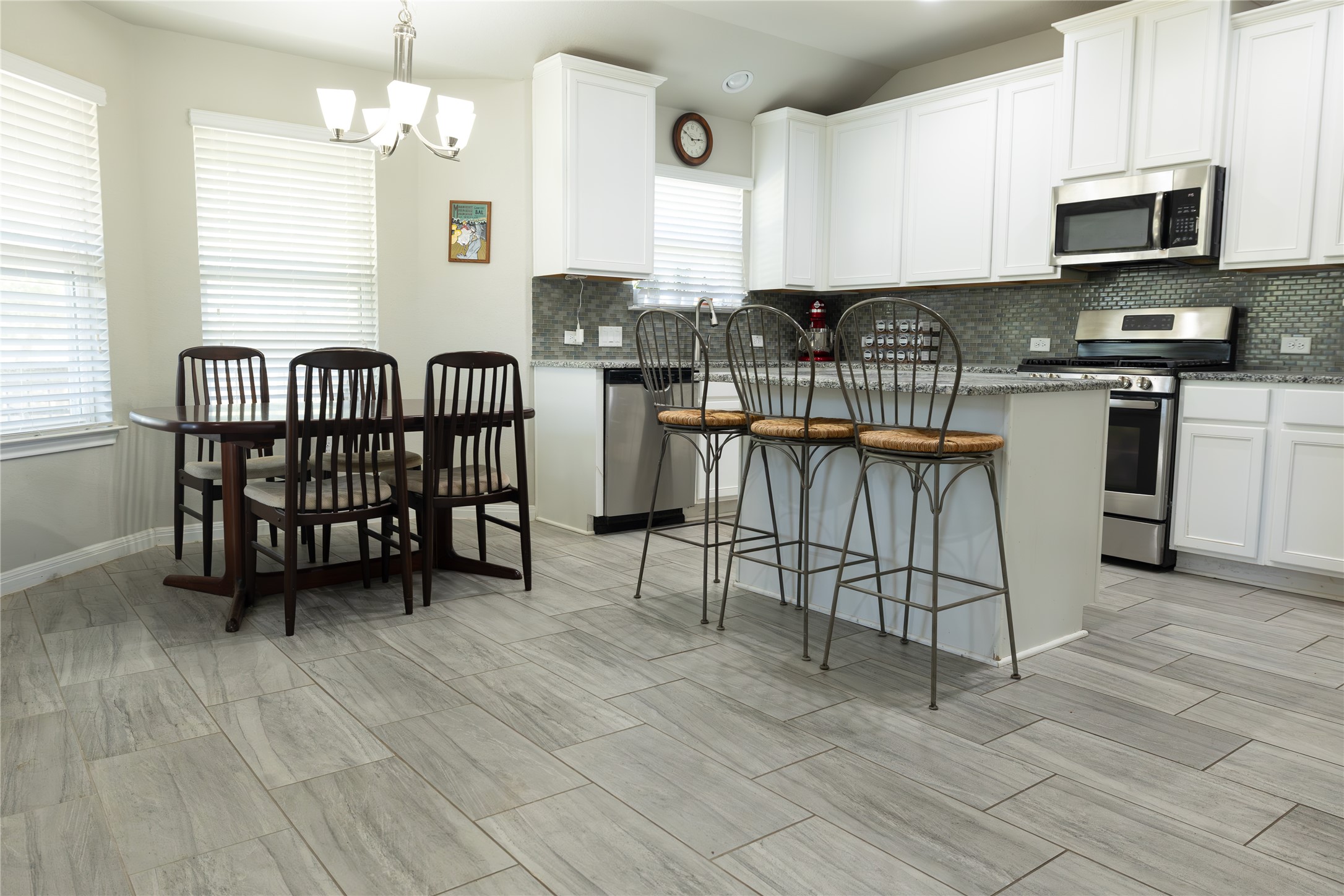 827 Savannah Cove Elgin, TX 78621 - Photo 2 of 31 Kitchen featuring decorative backsplash, kitchen island and breakfast bar
