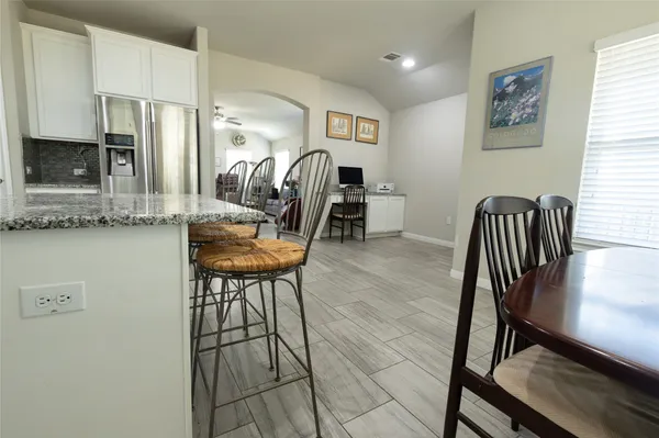a view of a dining room with furniture and a kitchen