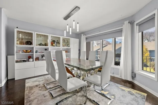 a dining room with furniture a chandelier and wooden floor