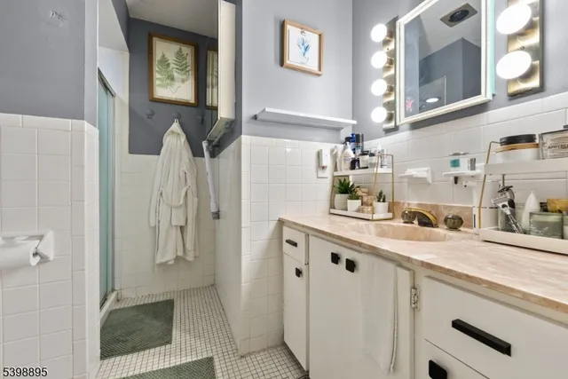 a bathroom with a granite countertop sink a mirror and shower