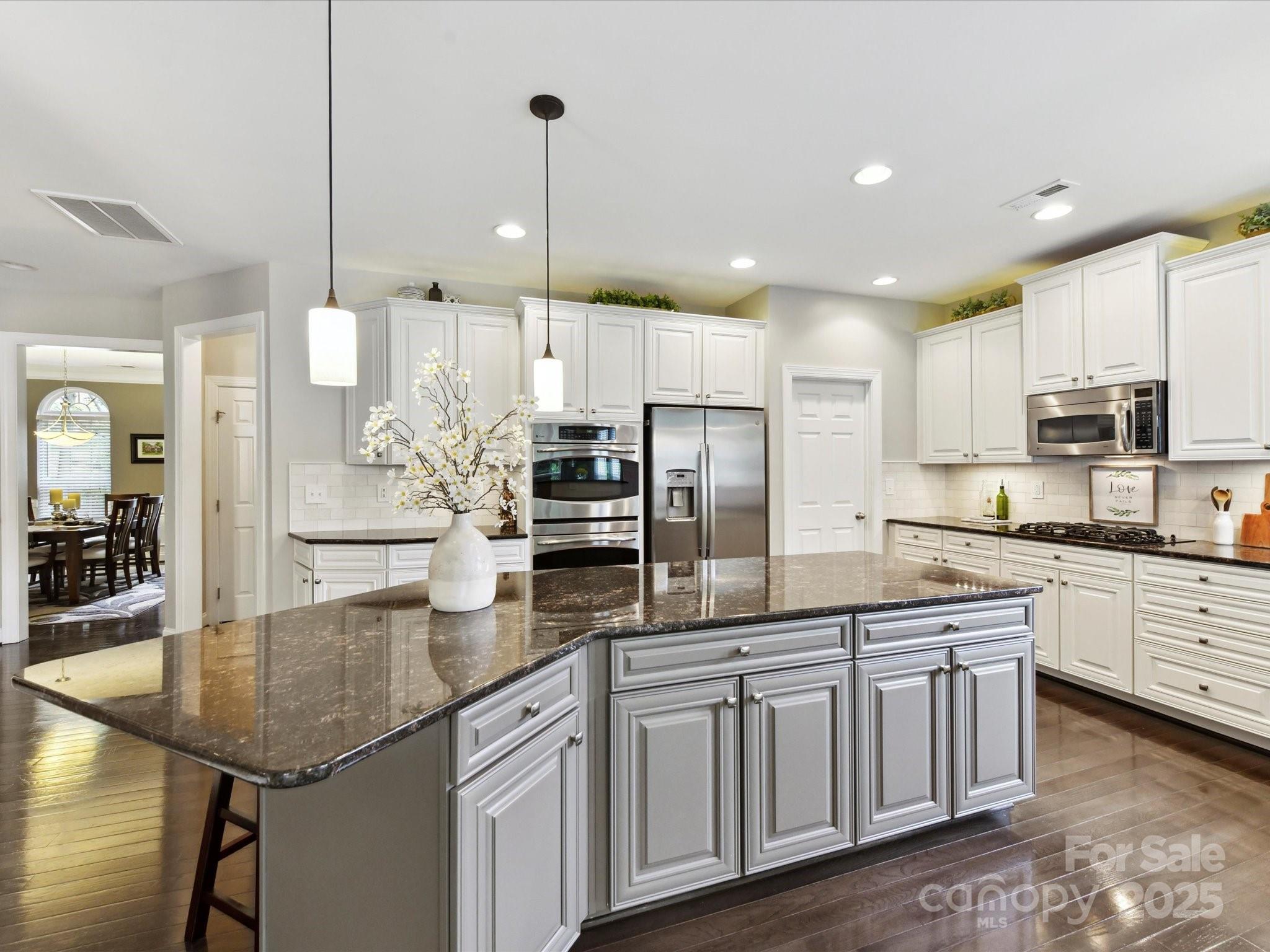 105 Beech Bluff Drive Mount Holly, NC 28120 - Photo 7 of 48 a kitchen with stainless steel appliances granite countertop a sink a stove a refrigerator a center island a stove and cabinets