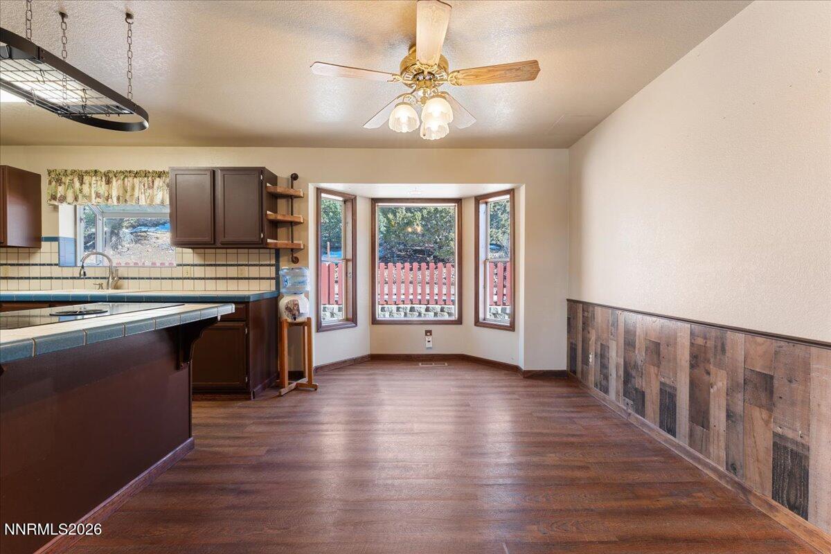 21381 Crestview Road Reno, NV 89521 - Photo 16 of 30 a open kitchen with stainless steel appliances granite countertop a stove top oven a sink dishwasher a dining table and chairs with wooden floor