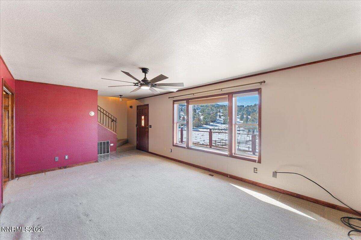 21381 Crestview Road Reno, NV 89521 - Photo 18 of 30 an empty room with chandelier fan and windows