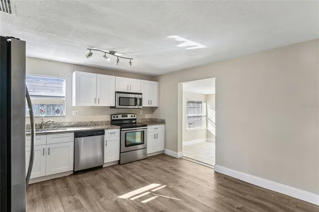 a kitchen with granite countertop a sink and cabinets