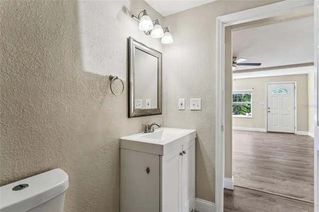 an empty room with wooden floor cabinet and windows