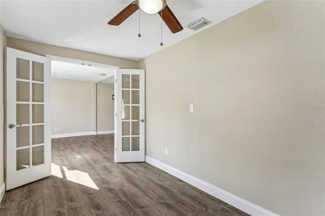 an empty room with a ceiling fan and carpet