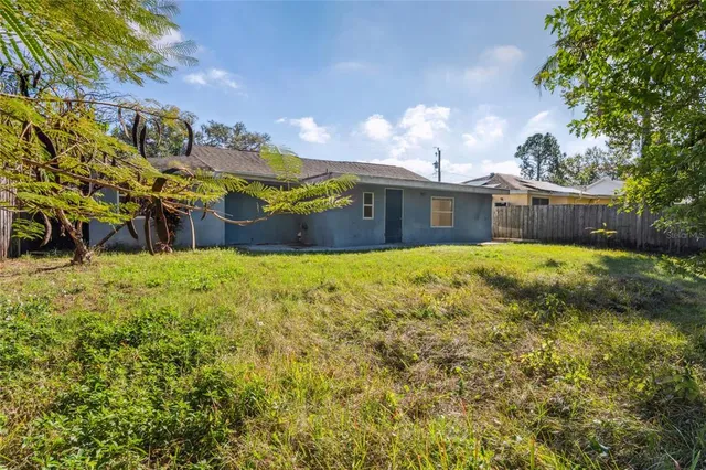 an aerial view of a house with a yard and large tree