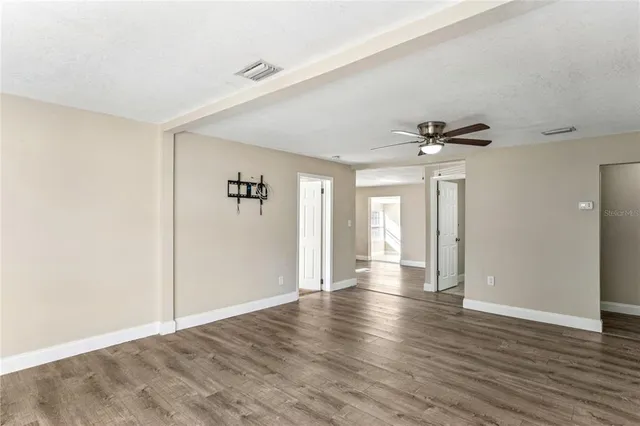 an empty room with windows and fan