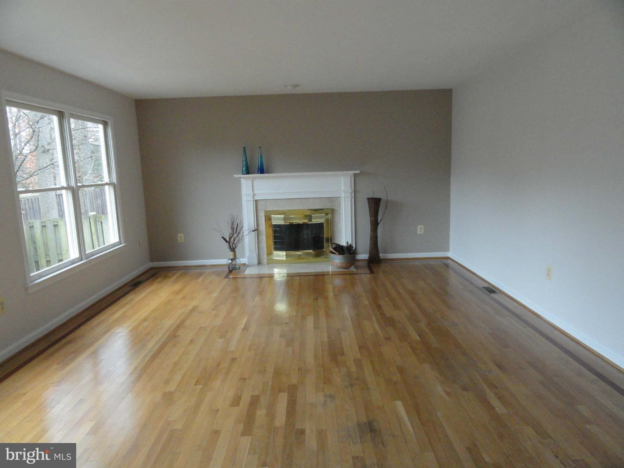 8660 Center Road, Unit 1 Springfield, VA 22152 - Photo 7 of 25 wooden floor fireplace and windows in an empty room