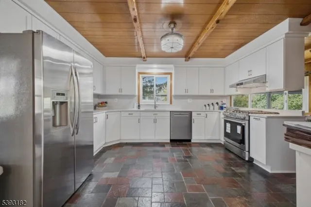 a kitchen with stainless steel appliances a stove a sink and a refrigerator