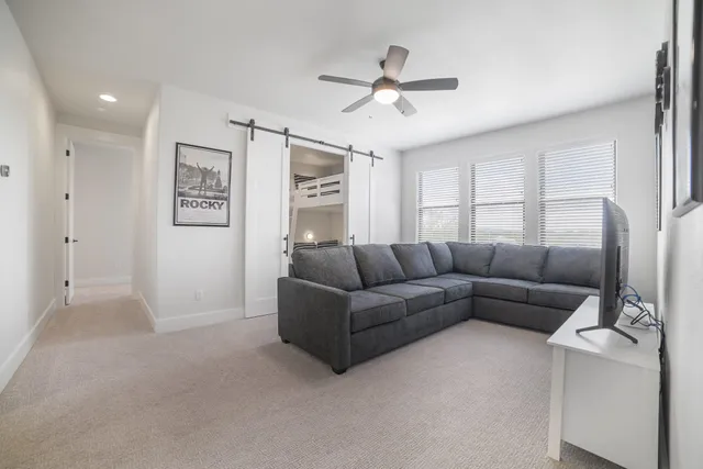 a living room with furniture and a ceiling fan