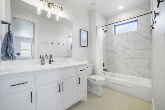 a bathroom with a double vanity sink toilet and shower