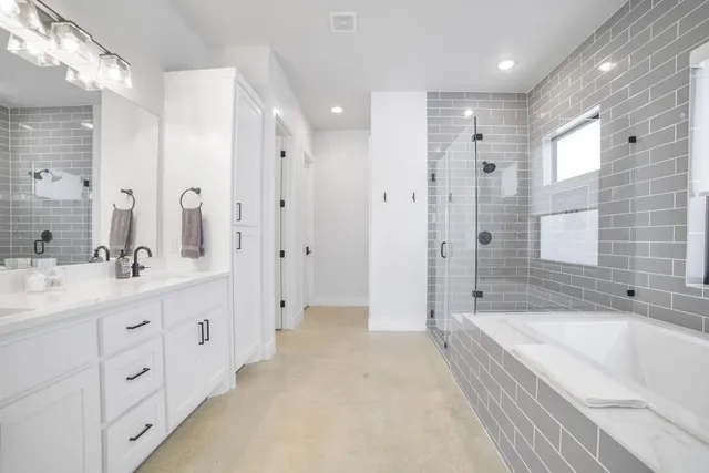 a spacious bathroom with a shower tub double sink and mirror