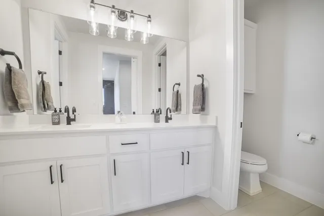 a bathroom with a double vanity sink mirror and toilet