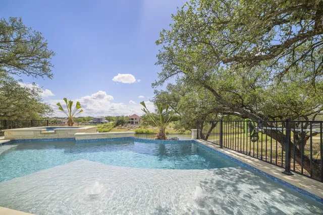 a view of a swimming pool with an outdoor seating and a tree