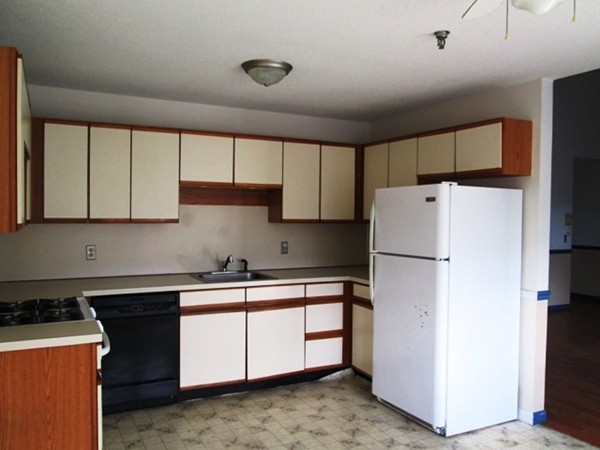 64 Tennis Plaza Road, Unit 2 Dracut, MA 01826 - Photo 2 of 20 a kitchen with a refrigerator sink and cabinets