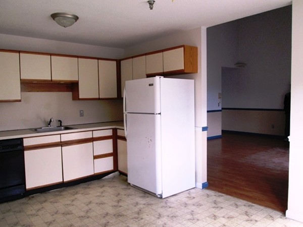 64 Tennis Plaza Road, Unit 2 Dracut, MA 01826 - Photo 4 of 20 a kitchen with refrigerator and cabinets