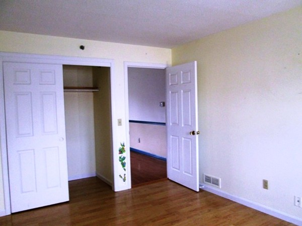 64 Tennis Plaza Road, Unit 2 Dracut, MA 01826 - Photo 6 of 20 an empty room with wooden floor and cabinet