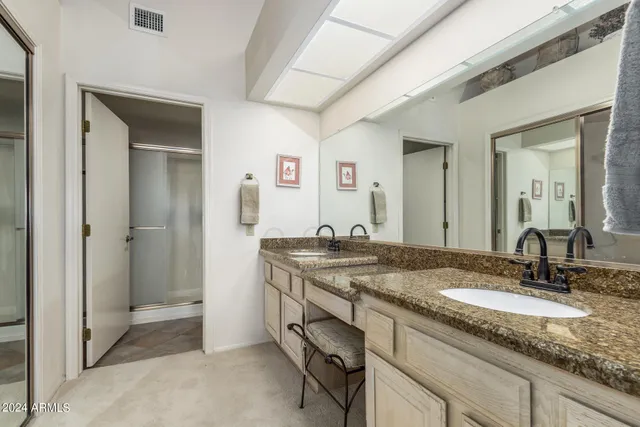 a bathroom with a granite countertop sink and a mirror