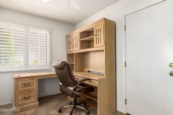 a view of a workspace with furniture and a window