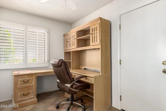 a view of a workspace with furniture and a window
