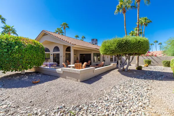 a view of a house with backyard and sitting area