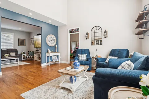 a living room with furniture a clock on wall and a rug