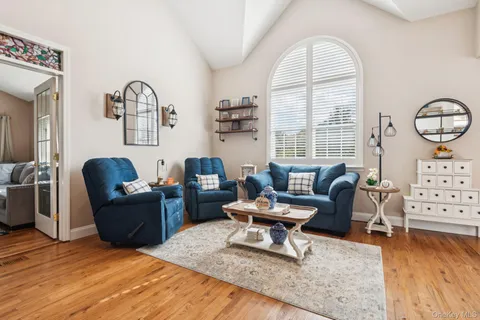 a living room with fireplace furniture and a large window
