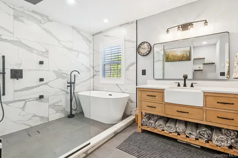 a bathroom with a double vanity sink a mirror and a bathtub
